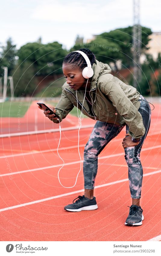 Sportler Sprinter hört erschöpft Musik Smartphone Afro-Look Konzentration Technik & Technologie Zelle Funktelefon Schutzhelm Mobile Athlet ethnisch