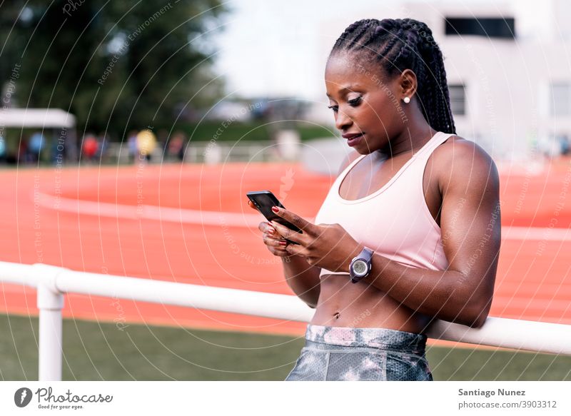 Athleten-Sprinter mit Mobiltelefon unterstützt Smartphone Afro-Look Technik & Technologie Funktelefon Mobile ethnisch afroamerikanisch Bahn Zug Training