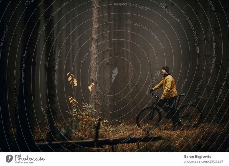 Junger Mann macht eine Pause beim Radfahren durch den Herbstwald Aktion aktiv Aktivität Abenteuer Athlet Fahrrad Radfahrer Biker Zyklus Übung extrem schnell