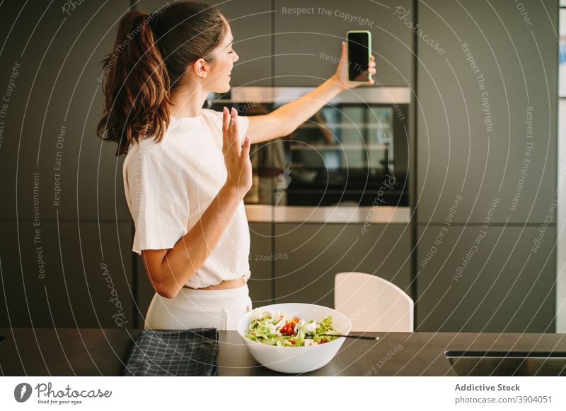Frau nimmt Selfie in der Küche Blogger Salatbeilage Lebensmittel Influencer soziale Netzwerke Smartphone Schalen & Schüsseln Gerät frisch Gemüse Mobile Mahlzeit