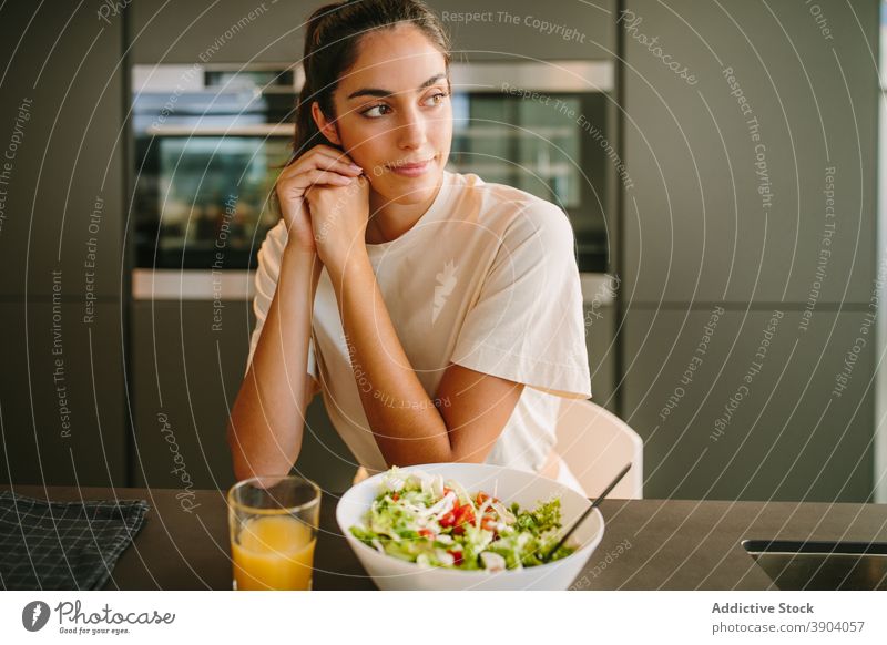 Frau sitzt am Tisch mit Saft und Salat Mittagessen Salatbeilage heimwärts orange Schalen & Schüsseln Gemüse Gesundheit gesunde Ernährung friedlich Glas Vitamin
