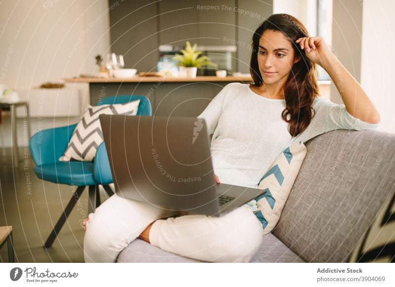 Junge Frau, die zu Hause am Laptop arbeitet benutzend freiberuflich abgelegen lässig jung online Arbeit Gerät Apparatur Browsen Internet Lifestyle Surfen
