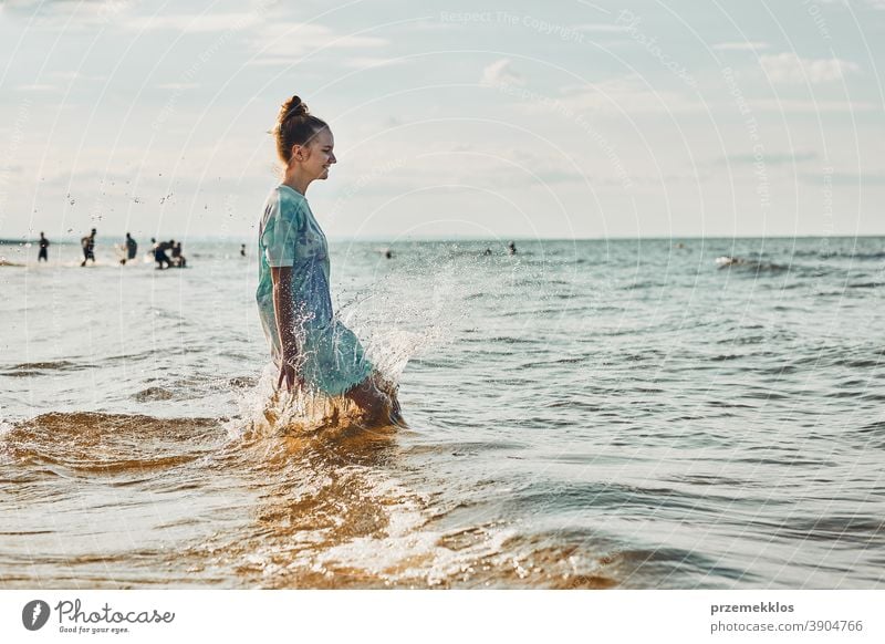 Mädchen, das es genießt, im Sommerurlaub über Wellen zu springen und seine Freizeit am Strand über dem Meer zu verbringen aufgeregt frei genießen positiv