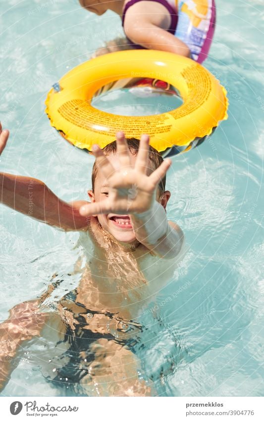 Glücklicher Junge spielt in einem Pool authentisch Hinterhof Kindheit Kinder Familie Spaß Garten Fröhlichkeit Freude Lachen Lifestyle spielerisch Spielen