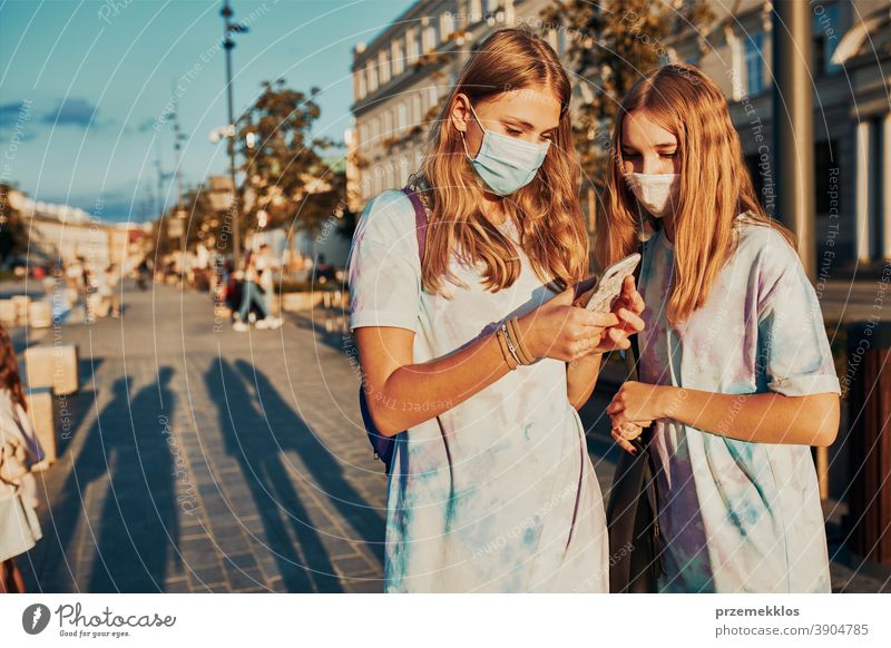 Junge Mädchen, die Smartphones benutzen, tragen die Gesichtsmasken, um eine Virusinfektion zu vermeiden Kaukasier Funktelefon Gespräch covid-19 Frau Lifestyle