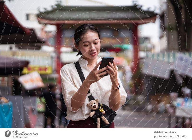 Junge Frau mit Smartphone zu Fuß auf der Straße benutzend Browsen Reisender prüfen Örtlichkeit Telefon Mobile jung asiatisch ethnisch Taiwan Tainan Tourismus