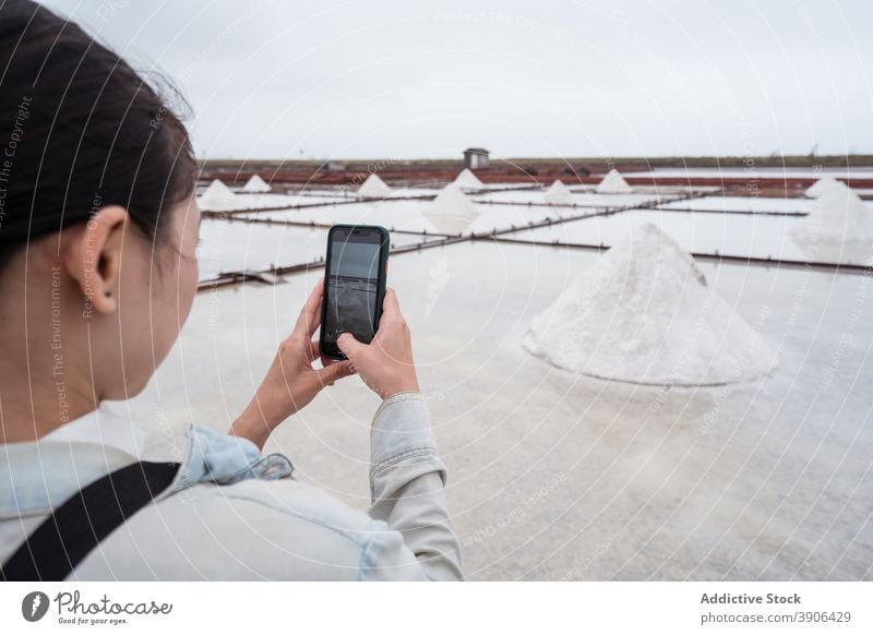 Frau beim Fotografieren von Salzteichen Teich Feld fotografieren Reisender Smartphone Natur Fabrik Mobile Telefon besuchen Umwelt Ressource Kristalle Bauernhof