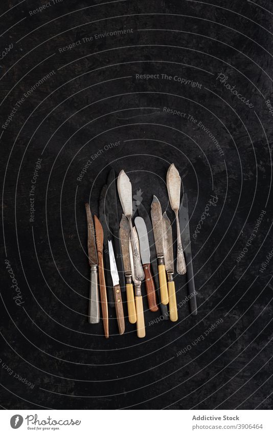Verschiedene alte Messer auf schwarzem Tisch Sammlung retro altmodisch altehrwürdig Silberwaren Kulisse sortiert Utensil verschiedene Metall Nostalgie rustikal