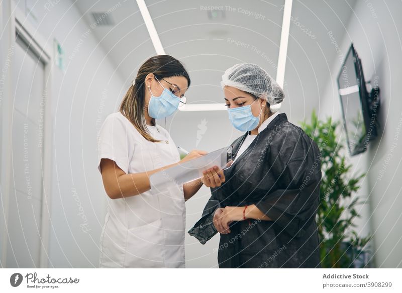 Weibliche Kosmetikerinnen in Uniform stehen im Korridor der Klinik Kosmetologie Frauen Zusammensein Schönheit Dermatologie Zwischenablage zur Kenntnis nehmen