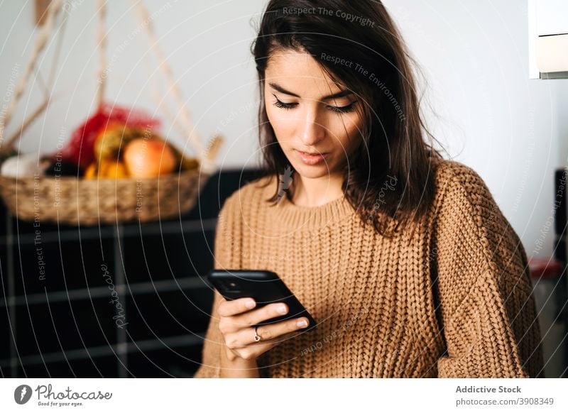 Frau trinkt Kaffee und surft auf dem Smartphone Browsen heimwärts Küche sich[Akk] entspannen Tasse Wochenende heimisch Abfertigungsschalter Internet Surfen