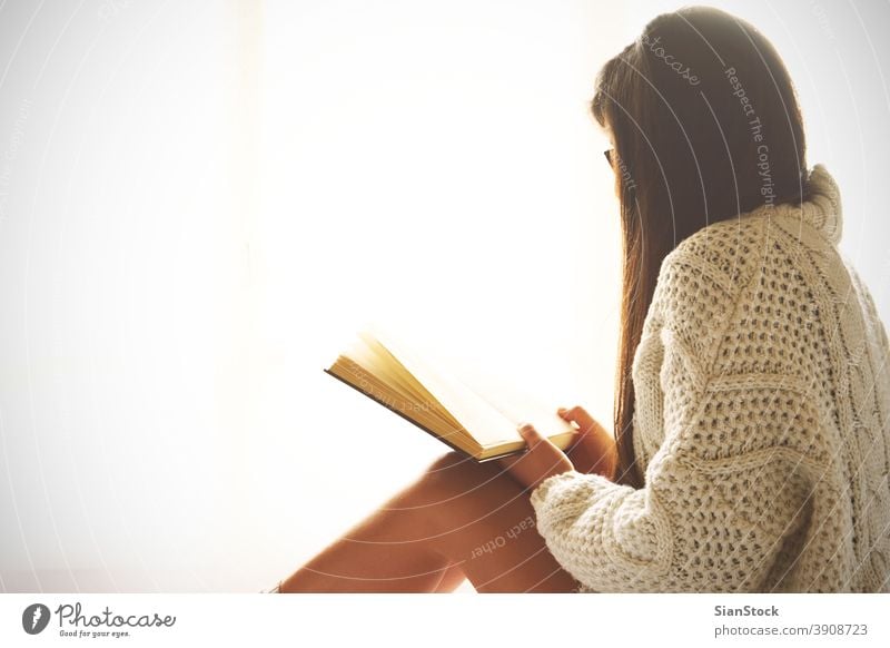 Junge Frau sitzt im Bett und liest ein Buch lesen Fenster Ansicht LAZY Sonntag Winter Kaffee Tasse Tee Brille Morgen Mädchen heimwärts sich[Akk] entspannen