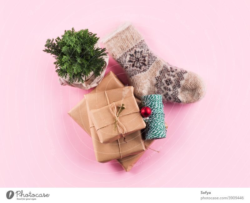 Minimaler Weihnachtsflachleger mit kuscheligen Socken auf rosa Weihnachten Winter Hintergrund gemütlich Geschenk Garn Baum Pflanze präsentieren Kasten oben