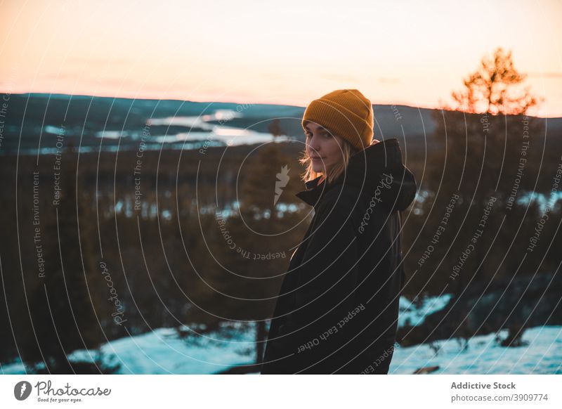 Reisende Frau stehend auf Hügel im Winter bei Sonnenuntergang Wald Reisender lebhaft Oberbekleidung Winterzeit warm Natur Immergrün Wälder ruhig Landschaft
