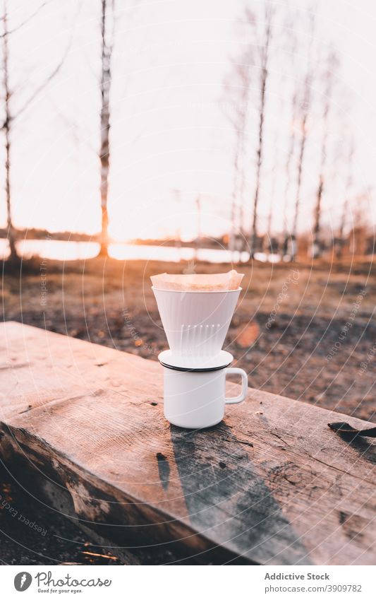 Metallbecher mit V60-Kaffeemaschine auf Holzbank im Wald v60 Tasse gemütlich Campingplatz Lager trinken Wälder Bank hölzern Kunststoff Natur kalt Saison Becher
