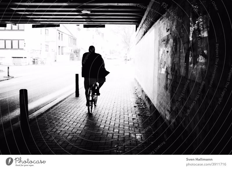 Silhouette auf Fahrrad fährt durch Tunnel Richtung Sonne Menschen Mann Sonnenlicht Glück Street streetfotografie urban zusammengehörig Spaziergang Erwachsene