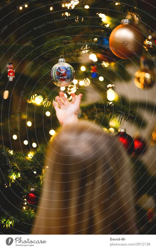 Kind betrachtet die am Weihnachtsbaum hängenden Christbaumkugeln Weihnachten & Advent vorfreude Begeisterung Tradition Kindheitserinnerung Tannenduft