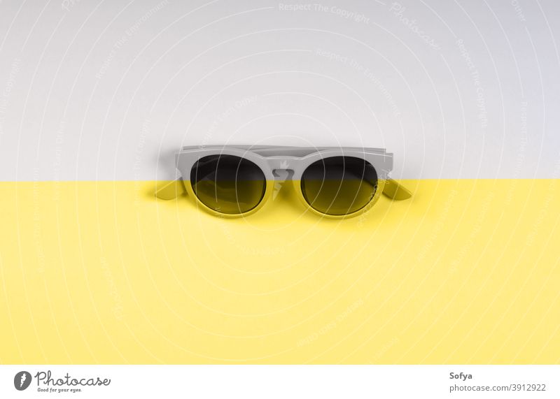 Leuchtende gelbe und graue Sonnenbrillen-Kulisse Duoton lichtvoll Farbe Mode Split Jahr endgültig Brille Hintergrund modern Sommer trendy Objekt sehr wenige
