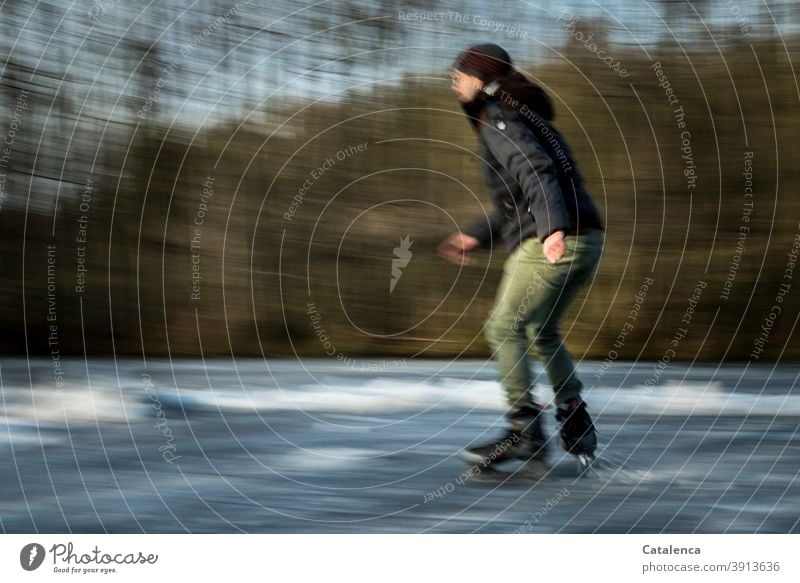 Junger Mann beim Eislaufen auf dem zugefrorenen Teich sportlich See Bäume Freude schnell Kälte und Frost Winter Spass Eislaufschuhe junger Mann Landschaft Baum