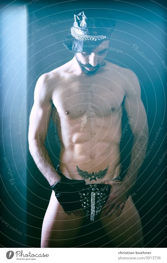 erotisches foto eines mannes nackt kappe nakter oberkoerper gay tatoo schnauzer bart unterhose string string tanga perlen glitzer model sex sexy sexy string