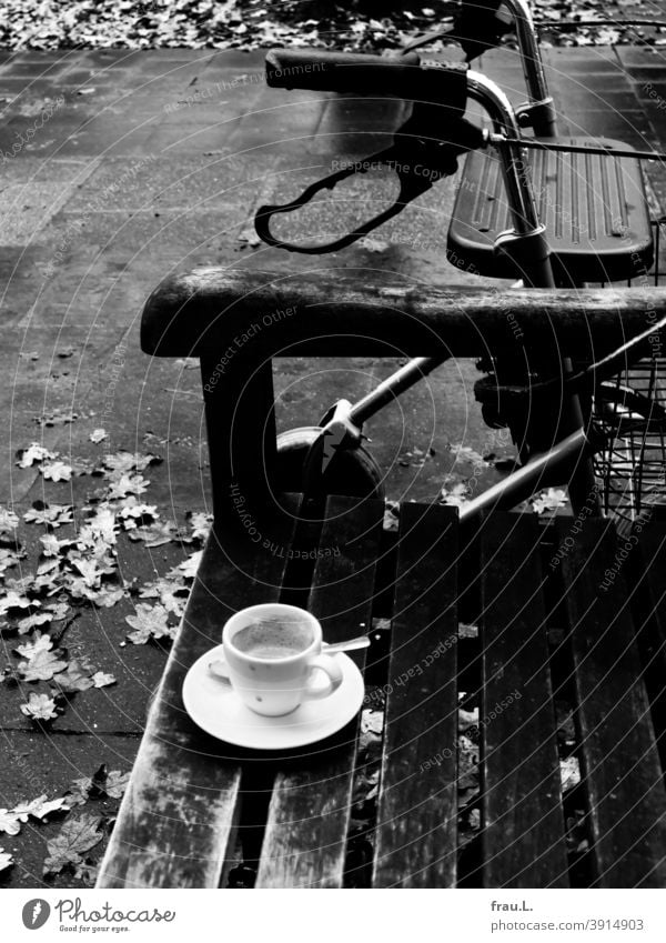 Eine Sitzbank, eine Espressotasse und ein Rollator Café Kaffeetasse Kaffeepause Herbst Blätter Fußweg