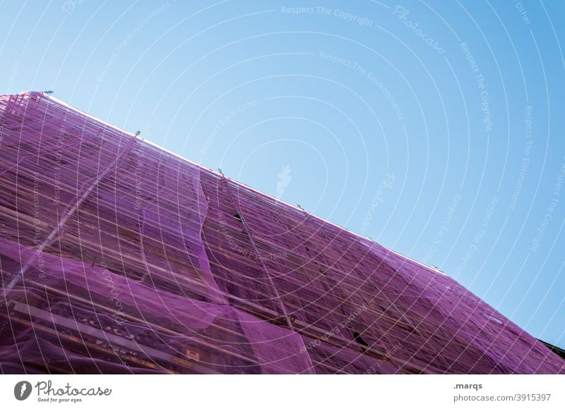 Lila eingepacktes Baugerüst Schutznetz verhüllen violett Kunststoff Himmel Modernisierung Baustelle Architektur Gebäude Schönes Wetter Fassade Gerüst Handwerk