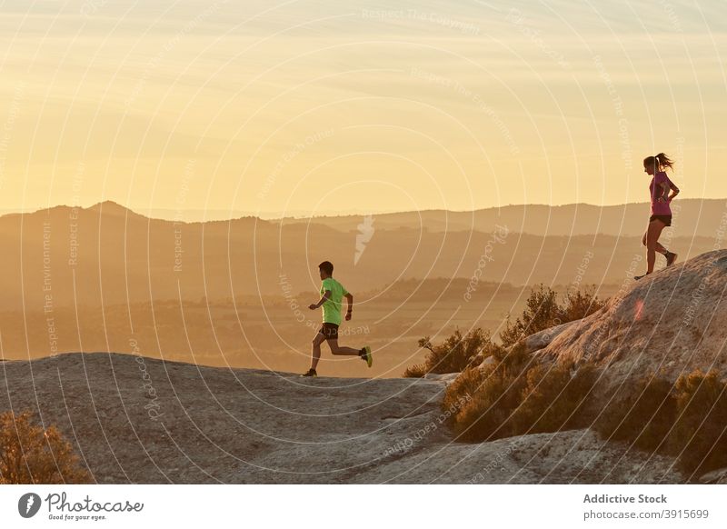 Junge Läufer trainieren in den Bergen bei Sonnenuntergang Berge u. Gebirge laufen Zusammensein Sportler Training Herz Sonnenlicht Athlet Hochland Gelände