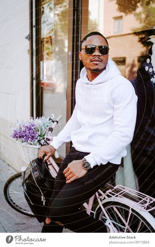 Schwarzer Mann in trendigem Outfit in der Nähe von Fahrrad in der Stadt Stil Großstadt Sonnenbrille trendy cool Straße männlich ethnisch schwarz Afroamerikaner