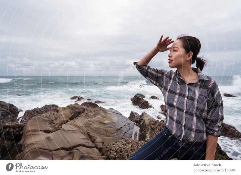 Asiatische Frau stehend auf Felsen in der Nähe von Meer Reisender MEER Küste Tourist Seeküste reisen Tourismus asiatisch ethnisch Ostküste wolkig Strand Urlaub