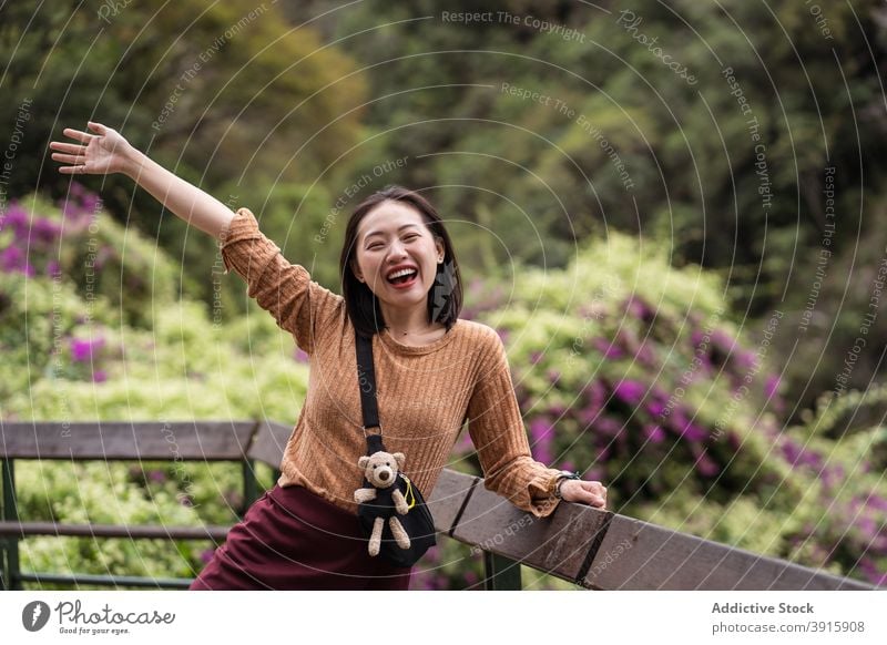 Entzückte ethnische reisende Frau im grünen Garten aufgeregt Urlaub Sommer heiter Freuen Sie sich Park Natur asiatisch Hualien-Stadt Taiwan hölzern Terrasse