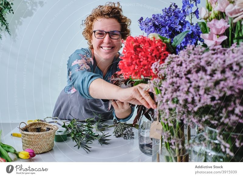 Florist erstellt Blumenstrauß im Salon Blumenhändler Frau Werkstatt Tulpe Haufen farbenfroh frisch Windstille Blütezeit Schürze Beruf Flora Verkäuferin