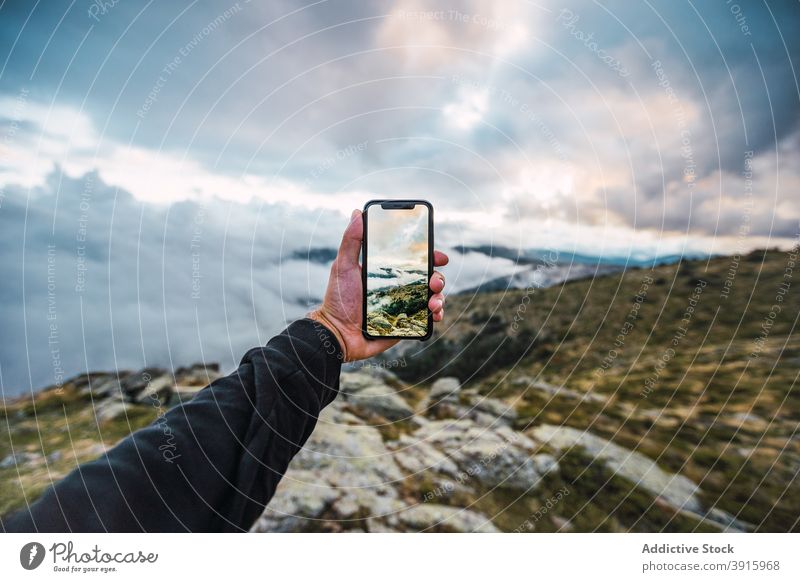 Crop-Reisende, die das Hochland mit dem Smartphone fotografieren Reisender Berge u. Gebirge unglaublich Natur Gelände felsig Wanderer Foto männlich Mobile