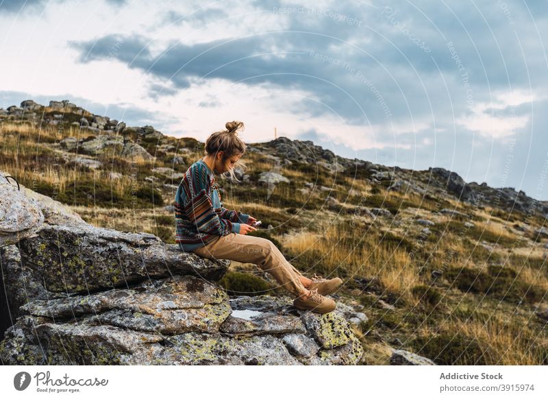 Reisende Frau beim Surfen auf dem Smartphone im Hochland Berge u. Gebirge Browsen Trekking Wanderer Pause sich[Akk] entspannen Reisender Felsen benutzend