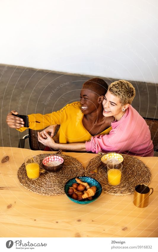 Schöne junge beste Freundin Frauen nehmen selfie mit einem Smartphone und lächelnd, während mit einem Frühstück zu Hause Selfie Freundschaft häusliches Leben