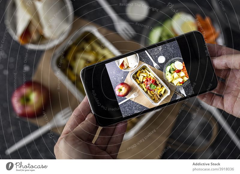 Person, die ein Foto von Essen zum Mitnehmen macht Food-Fotografie fotografieren Imbissbude Blogger Smartphone Mittagessen soziale Netzwerke Lebensmittel