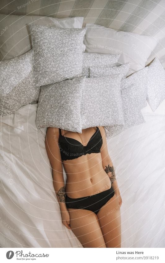Inked Mädchen schlafen mit Dutzenden von Kissen in ihrem schwarzen Dessous. Sexy Kurven und Tattoos peppen sie auf. Der Sommer Körper bekommt kaum besser als diese.
