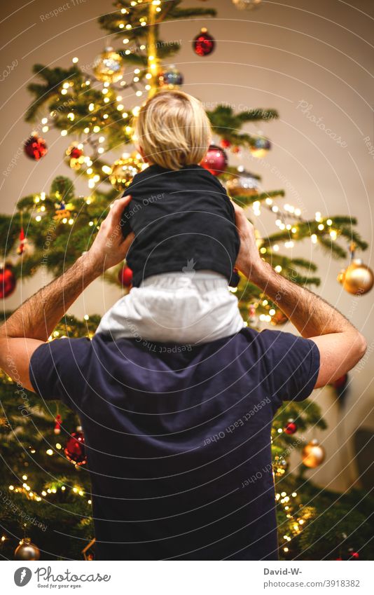 Vater und Kind vor dem geschmückten Weihnachtsbaum Weihnachten & Advent Familie Heiligabend Zusammensein Eltern Freude Gemeinsam glücklich