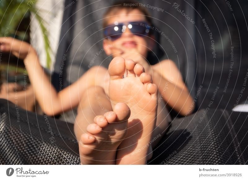 Kind mit Sonnenbrille liegt auf einem Liegestuhl Sommer Füsse Beine Zehen liegen erholung ferien Erholung Barfuß Ferien & Urlaub & Reisen Fuß Außenaufnahme