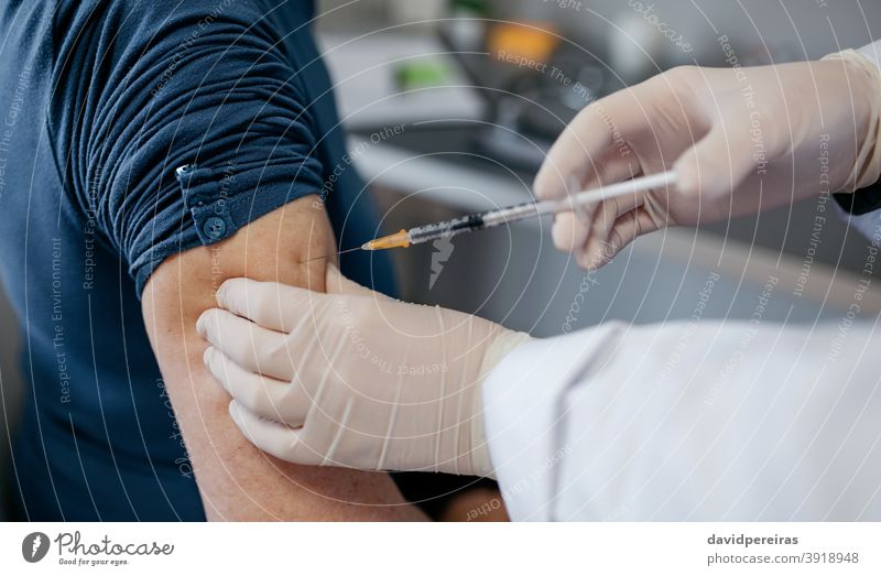 Arm eines nicht erkennbaren Erwachsenen mit Coronavirus-Impfstoff Impfung Spritze covid-19 Erwachsener Nahaufnahme unkenntlich Arme Arzt Hand geduldig Nadel