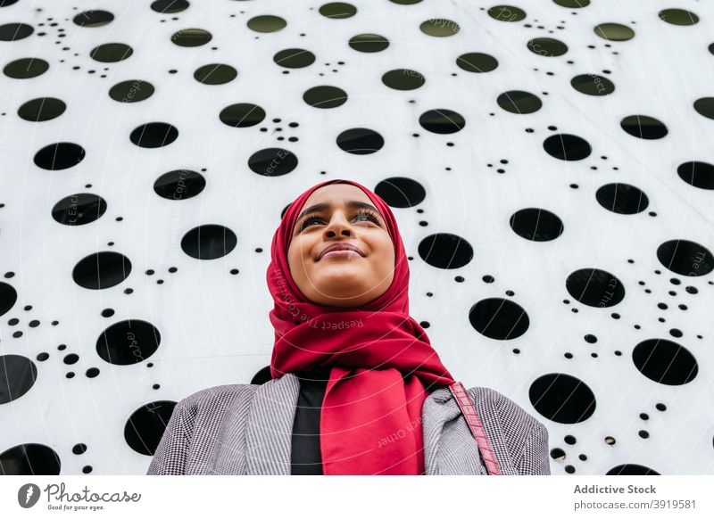 Stilvolle ethnische Frau im Hijab auf der Straße Kopftuch Lächeln urban modern heiter Großstadt charmant arabisch Tradition froh Optimist positiv Glück angenehm