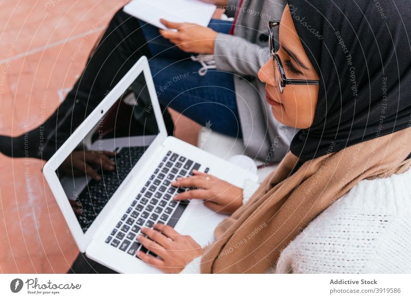 Ethnische Frauen im Hijab beim Studieren auf dem Campus muslimisch lernen Schüler vorbereiten Prüfung Prüfungsvorbereitung ethnisch arabisch Bank grün Garten