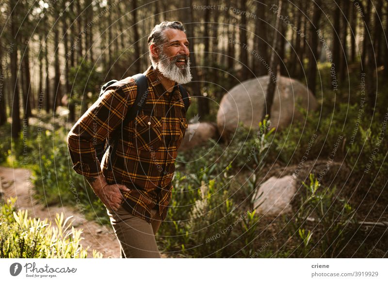 Glücklich Senior Mann lächelnd auf Wanderung im Wald wandern sonnig Ruhestand Abenteuer Spaß Wohlbefinden laufen Lächeln Lifestyle Freizeit Lachen positiv