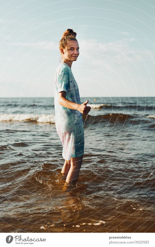 Mädchen zeigt okay Geste stehen in einem Wasser verbringen eine freie Zeit über ein Meer während des Sommerurlaubs aufgeregt genießen positiv Sonnenuntergang