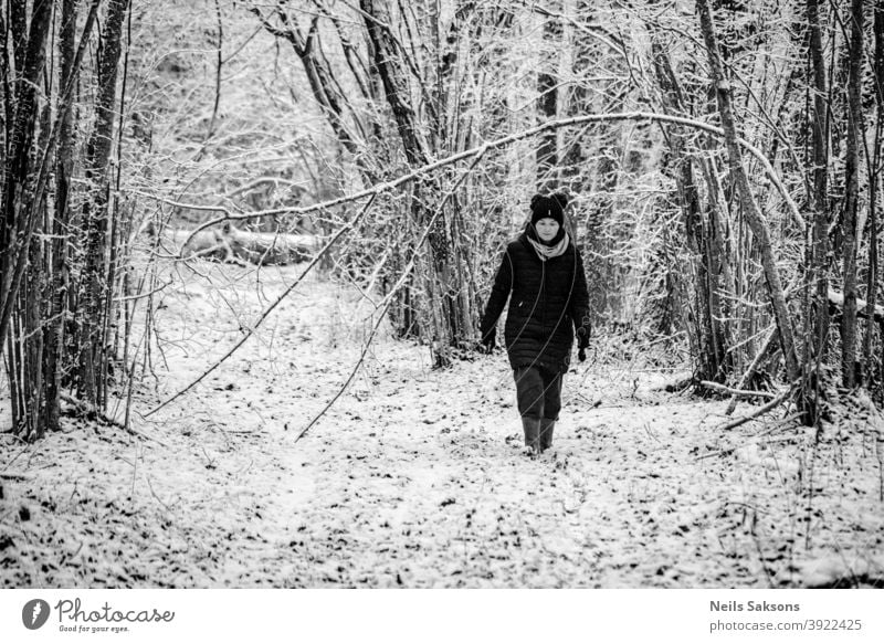 Frau zu Fuß im Wald im Winter Wald Schnee Winterwald kalt Baum Natur Landschaft Nachlauf Eis Haselnussstrauch warm angezogen gut gekleidet laufen Gummistiefel