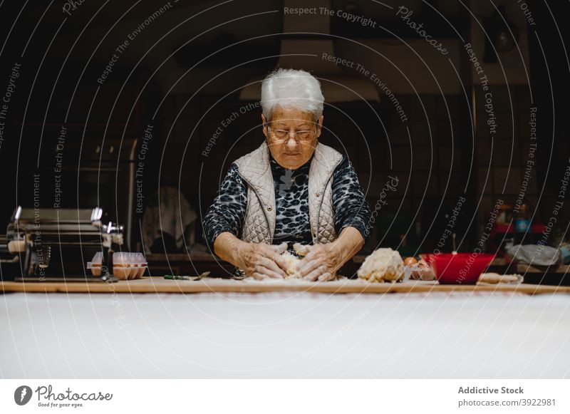 Ältere Frau knetet Teig in der Küche kneten Teigwaren Koch roh Italienische Küche Tortellini Tradition selbstgemacht Knödel Senior Lebensmittel heimwärts