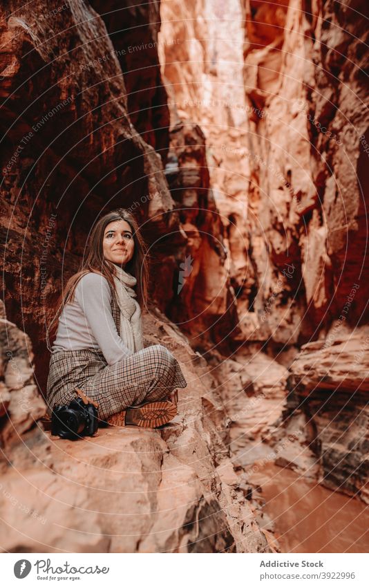 Lächelnde reisende Frau im Canyon Schlucht Reisender Felsen Gelände Tourist Urlaub heiter Wadi Rum Jordanien Ausflug sitzen sich[Akk] entspannen Abenteuer