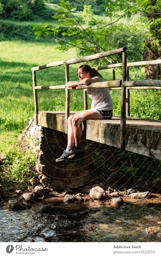 Frau entspannt auf Brücke im Wald Wälder Sommer sich[Akk] entspannen Fluss genießen sorgenfrei Natur friedlich ruhen Baum sitzen Freiheit Wasser Bach alt ruhig