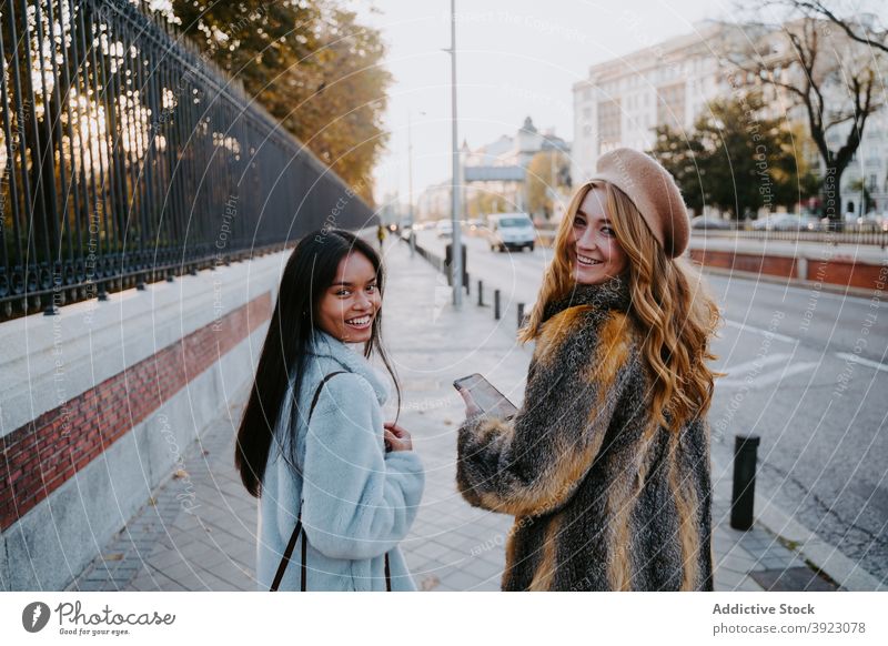 Fröhliche multiethnische Frauen gehen die Straße entlang schlendern Großstadt Freund Freundschaft heiter Wochenende genießen Herbst rassenübergreifend