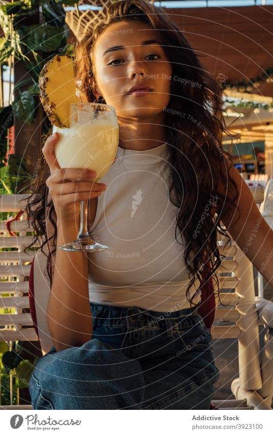 Junge Frau trinkt Fruchtgetränk im Cafe trinken Café frisch Getränk Kälte Sommer Terrasse Glas Ananas tausendjährig brünett jung Erfrischung