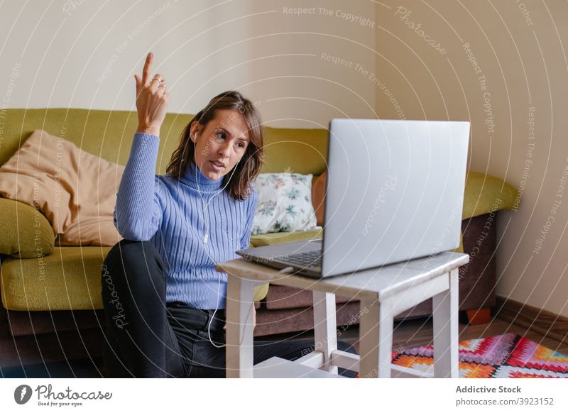 Fernarbeitende Frau mit Online-Meeting über Laptop zu Hause Arbeit abgelegen Videoanruf online Sitzung diskutieren Entfernung Erwachsener lässig Gerät Apparatur