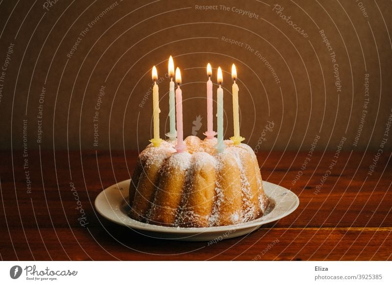 Geburtstagskuchen mit brennenden Kerzen auf einem Teller Geburtstagskerzen Kuchen happy Birthday Geburtstagsfeier Guglhupf Feste & Feiern Kindergeburtstag